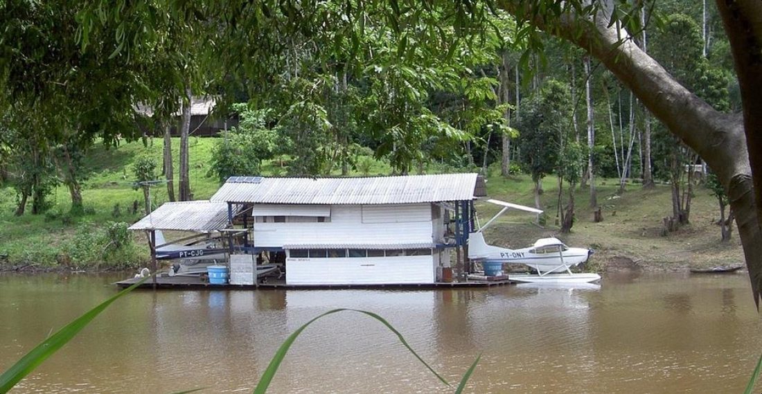 The floating houseboat on the upper Amazon with the float plane tied alongside.